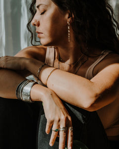 A girl sitting near the window wearing Leia Zumbro's artisan jewelry