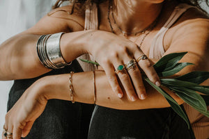 A girl wearing Leia Zumbro Handmade jewelry and holding a leaf